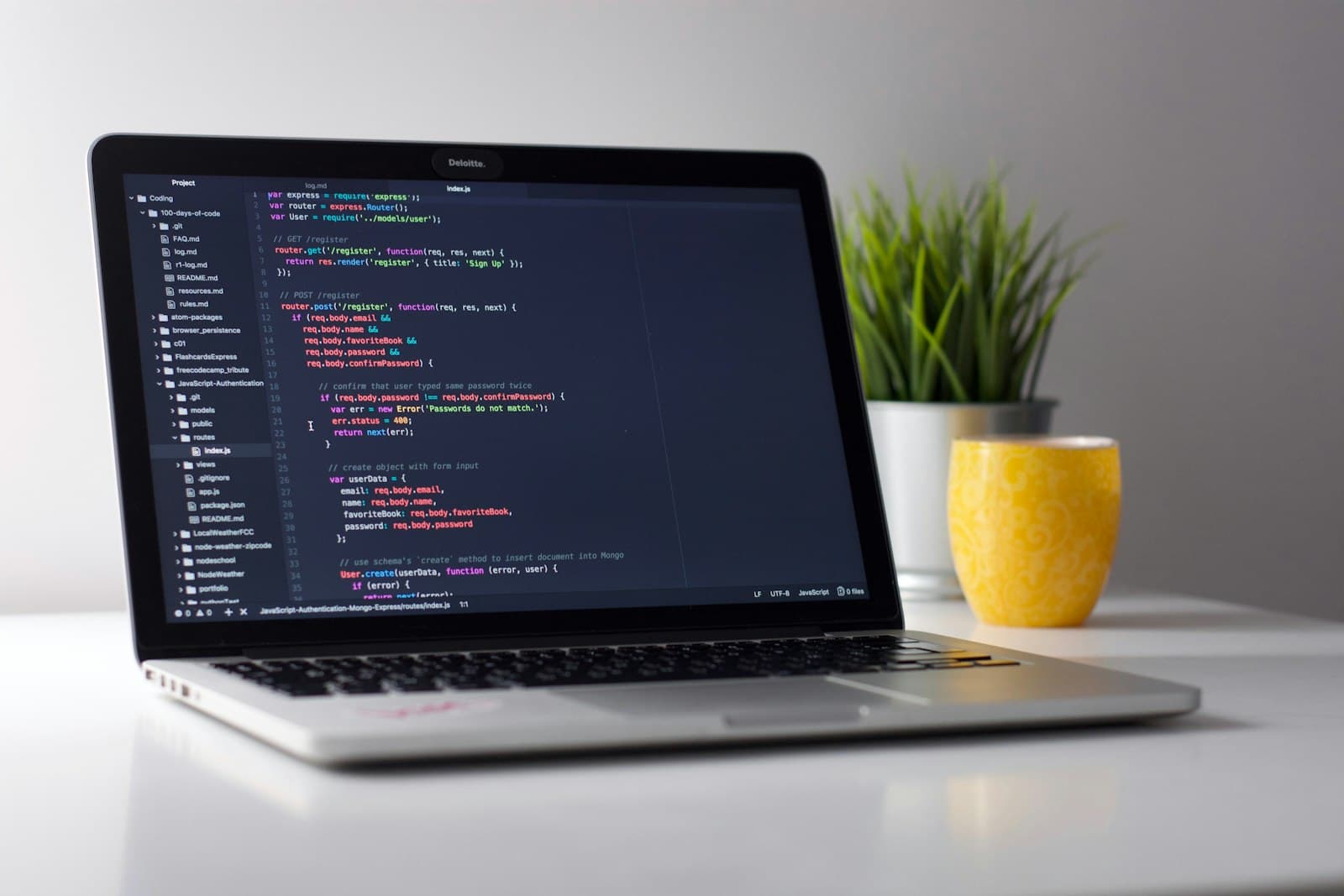 Laptop displaying code on a wooden desk